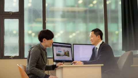 International student speaking to an adviser at a desk