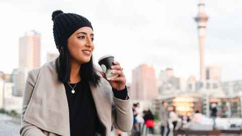 Young woman sipping take out coffee in auckland