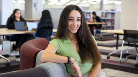 Smiling woman seated in a study area
