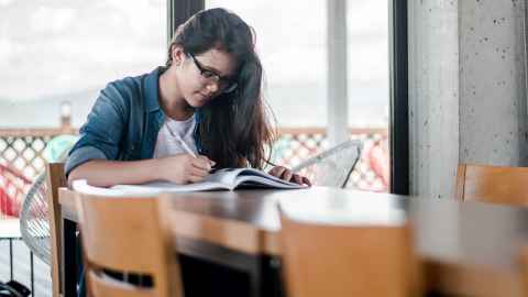 Woman reading a text book.