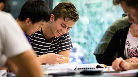 Students sitting together looking at notes.