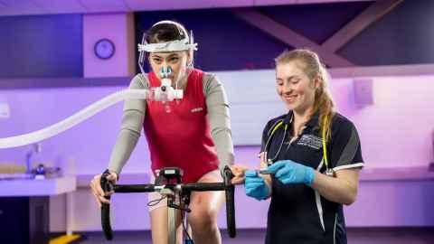 Person on exercise bike is monitored by a student using specialist equipment