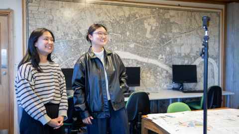 Two Urban Planning students stand inside a teaching studio on campus during filming of the tour video.