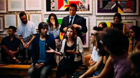 A group of people seated involved in deep discussion.