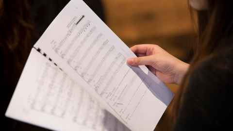 A woman reading music.
