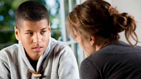A young man and woman talking to each other.