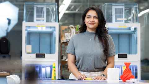 A woman in a room with design-related machinery.