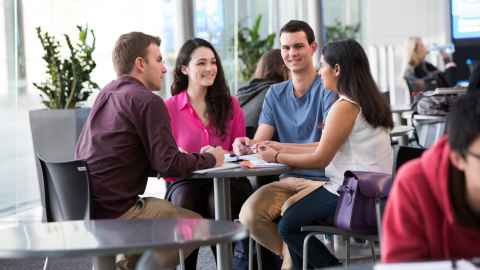 A group of young people sitting around a table.