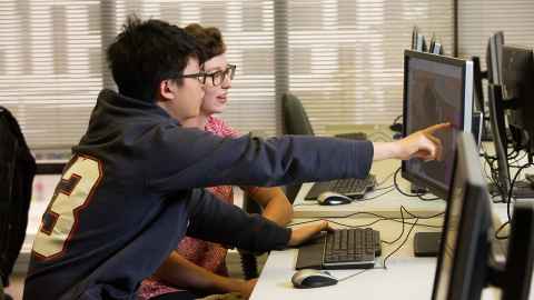 Two people looking at a computer screen.