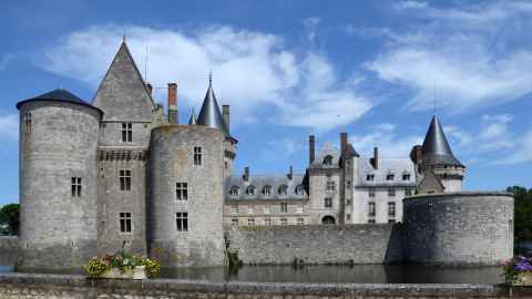 A castle made of stone, surrounded by water.