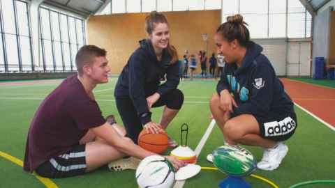 Three people in a gymnasium