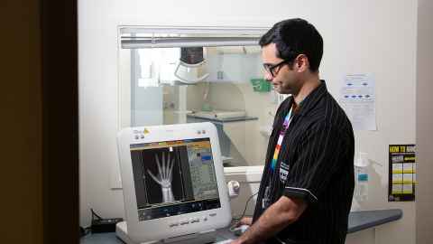 A student and a teacher look at a medical image on a screen