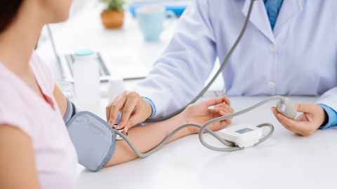 A doctor taking a woman's blood pressure.