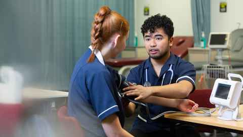 Two nurses, on taking the other's blood pressure.