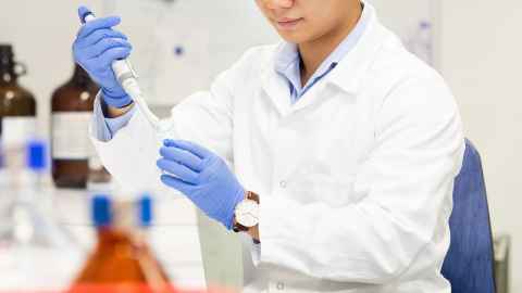 A man in a white coat, in a lab.