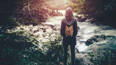 A person looking out onto river rapids.