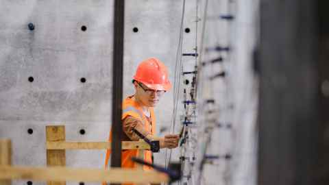 A man on site in high-vis and hard hat.