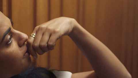 Woman looking into the distance thinking with a hand to her face