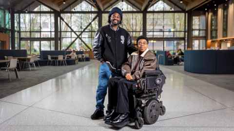 Ayolabi and his support worker smiling in front of the camera