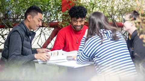 students outside sitting at a table