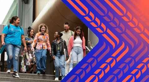 A group of students walking down concrete steps chatting together and laughing