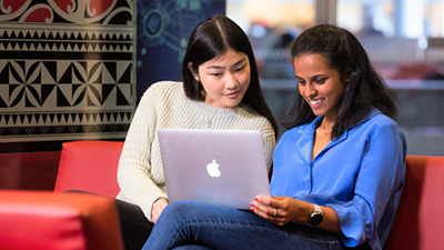 Two students looking at a laptop