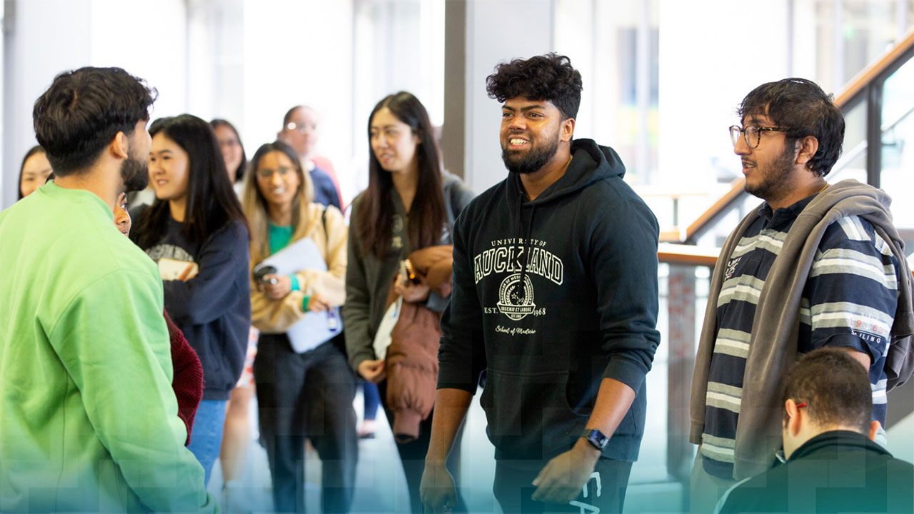 A group of students talking in an atrium.
