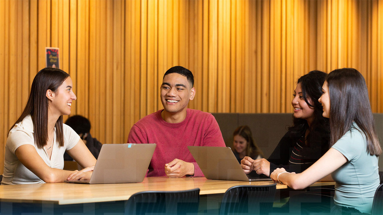 Three students working at table.