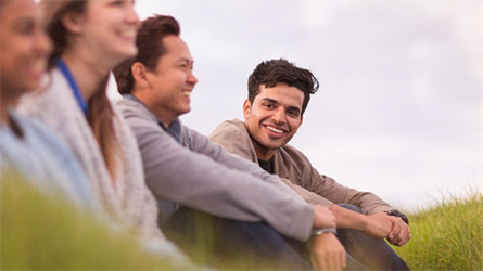 Students sitting in long grass.