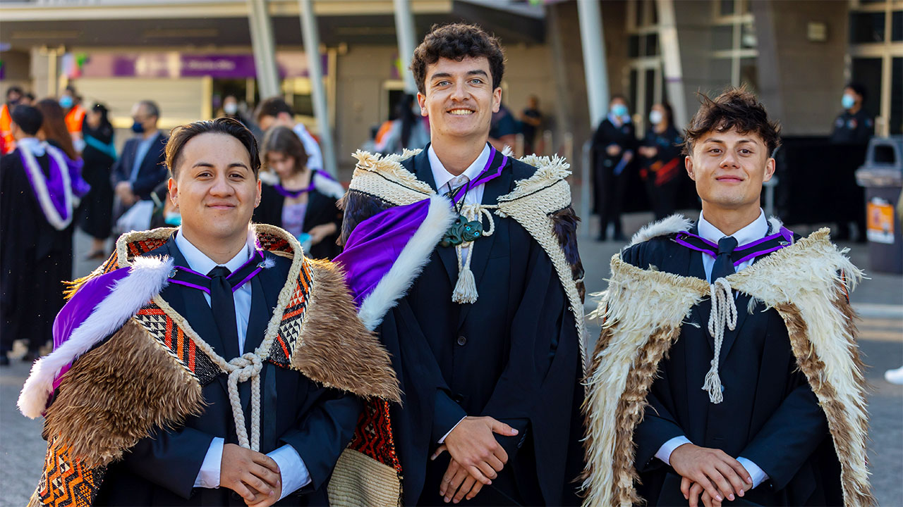 Three students in graduation regalia