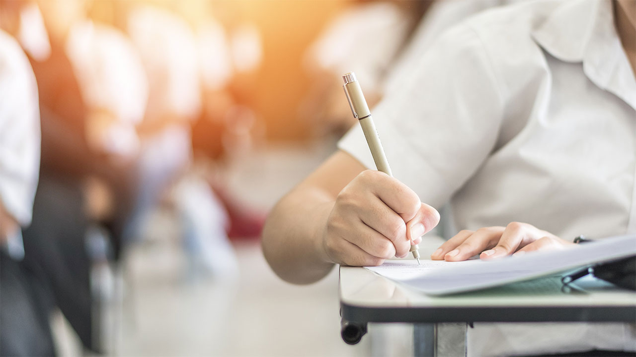 Closeup of a person writing on paper.