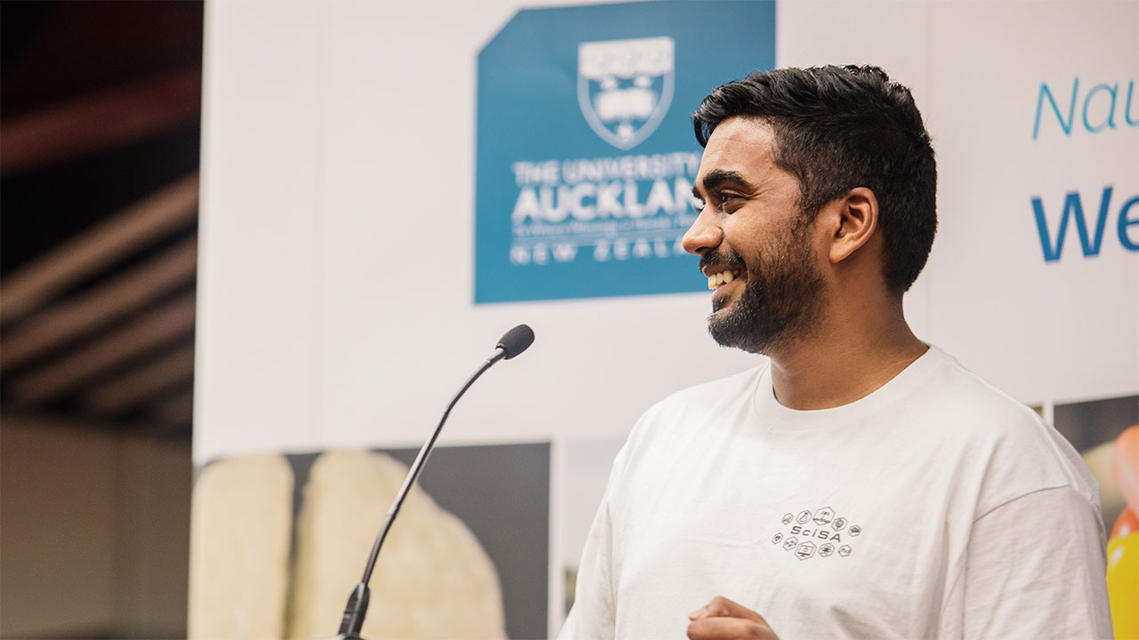 A student on stage speaking into a microphone
