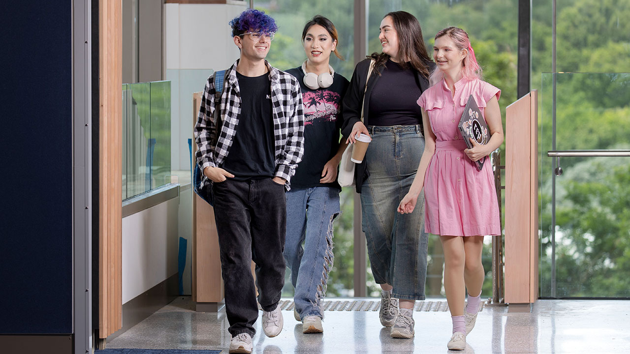Group of students chatting while walking through a building.