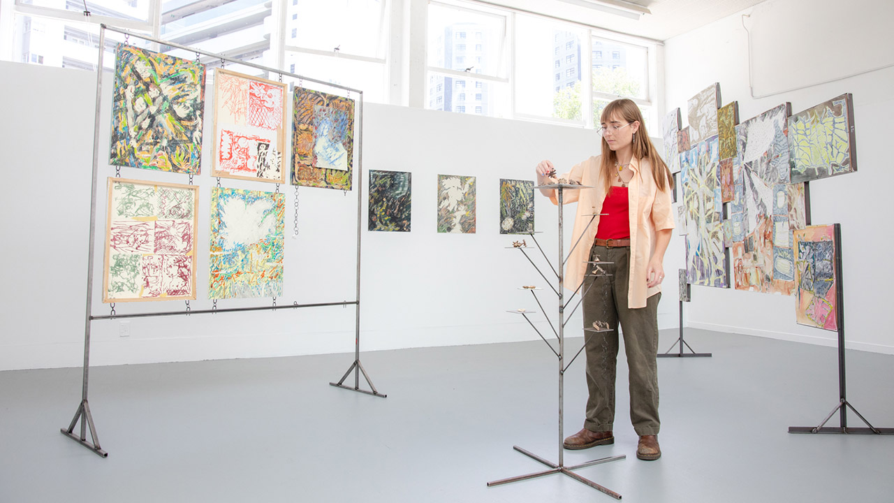 Student arranging her art in a gallery.