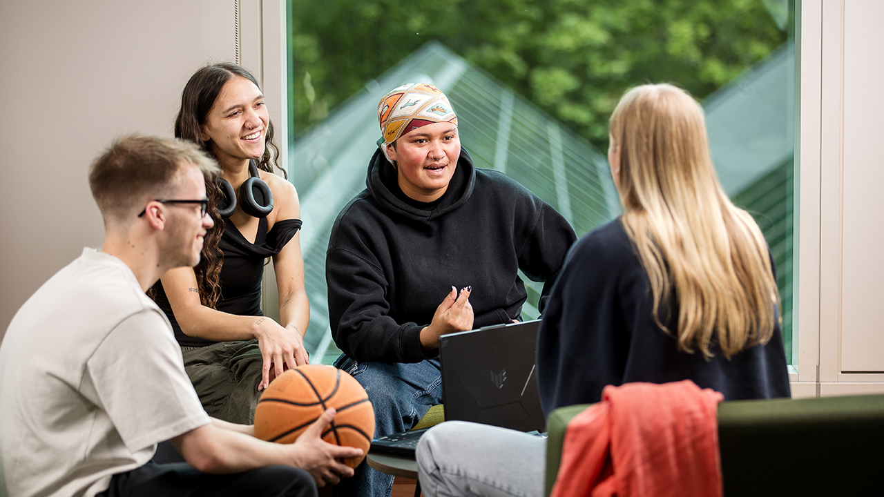 Group of seated students happily chatting together.