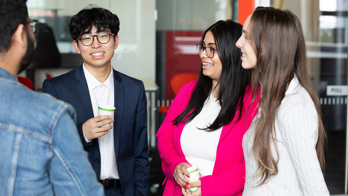 Group of students happily talking together in a group.