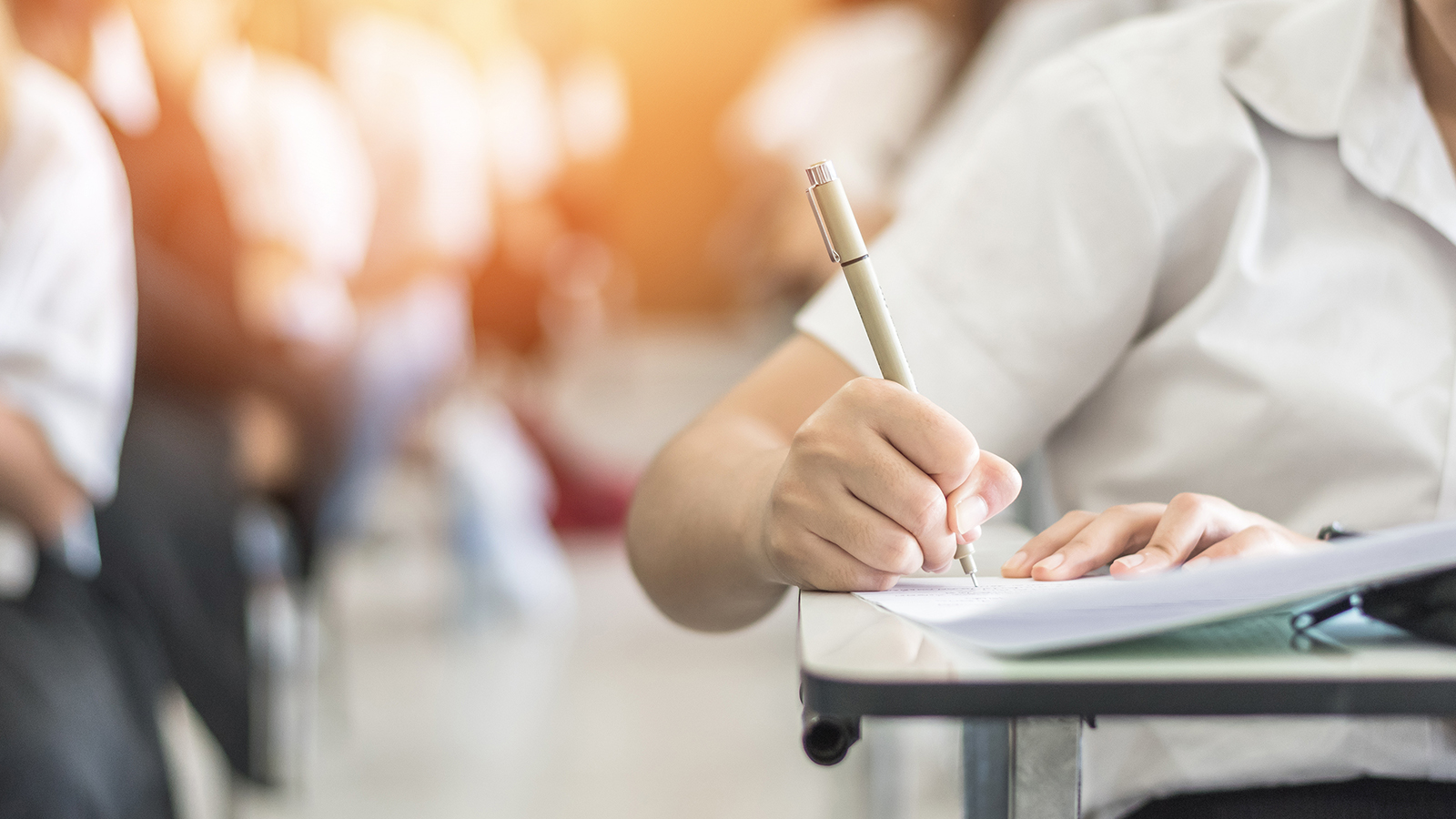Student sitting at a desk writing.