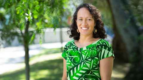Woman outside in front of trees